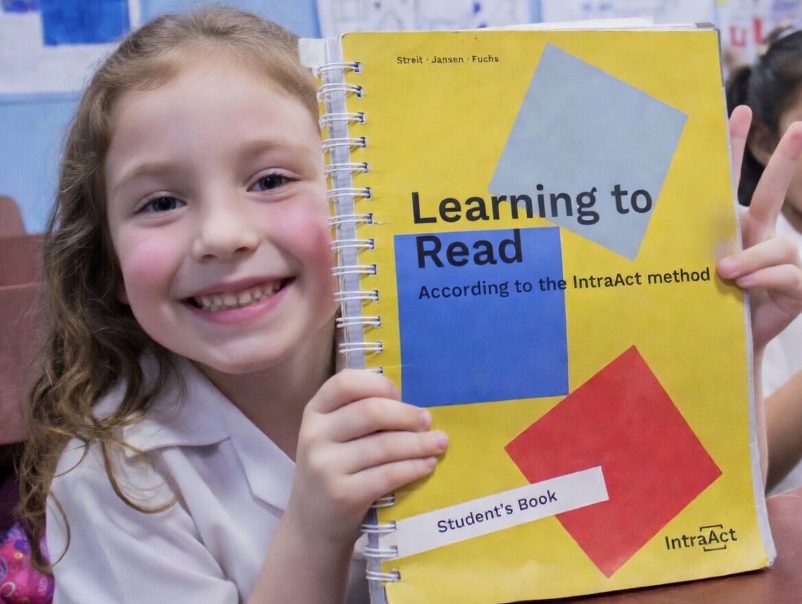 Student holding IntraAct Learning to Read book